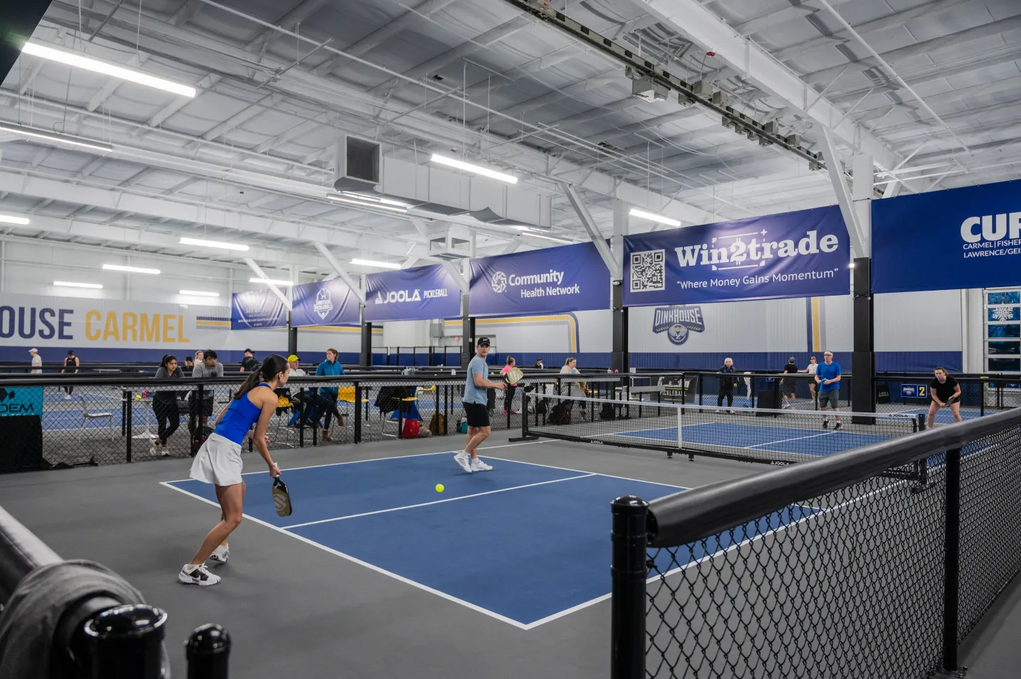vibrant pickleball venue with colorful courts, community atmosphere, recreational facility